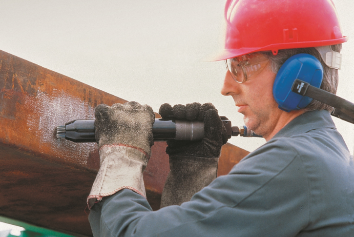 Photo of a worker using a chisel or a needle scaler