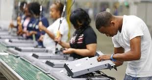 Picture depicting workers assembling electronics along an assembly line